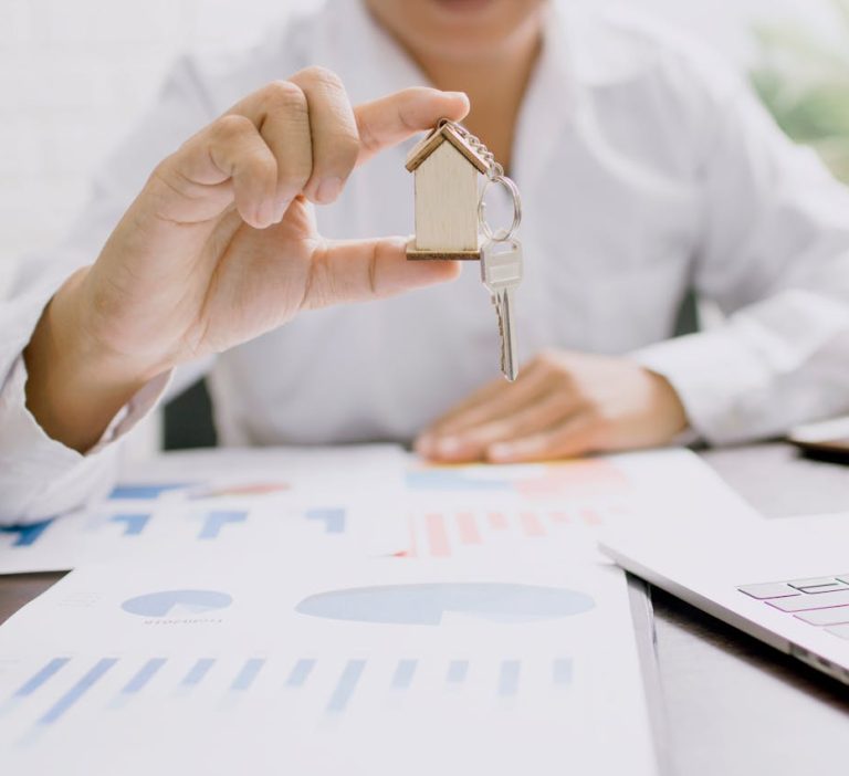 mężczyzna trzymający w rękach klucz do domu na sprzedaż